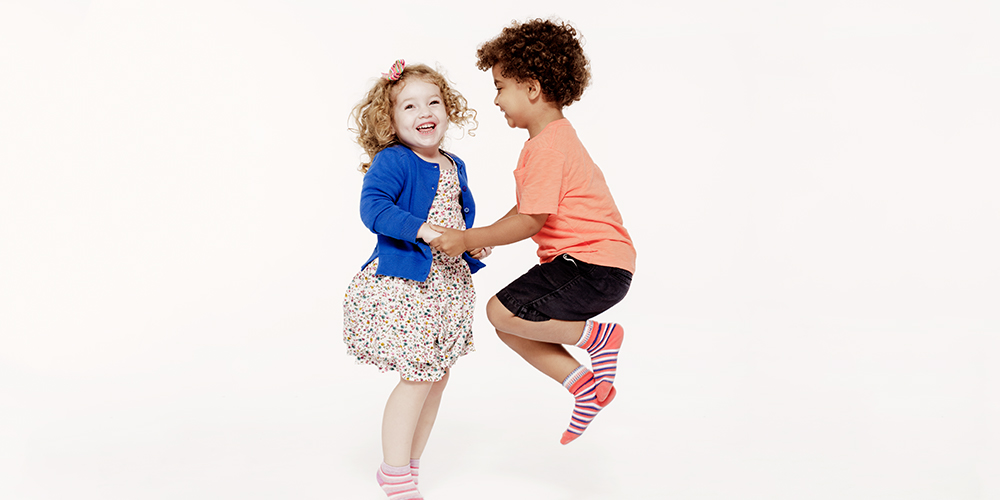 A little boy and gurl are plying together and jumping