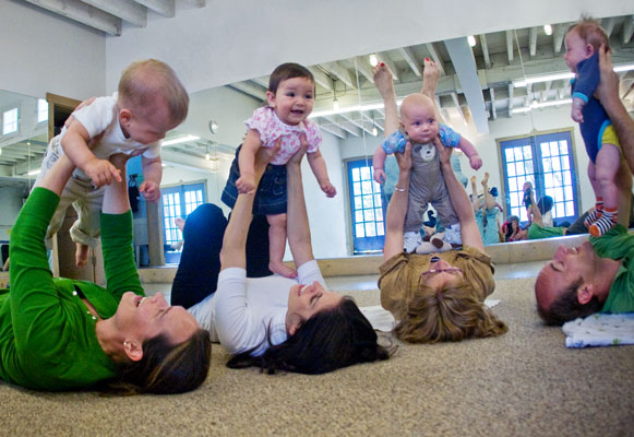 Mother and fathers are lifting their kids up in the air